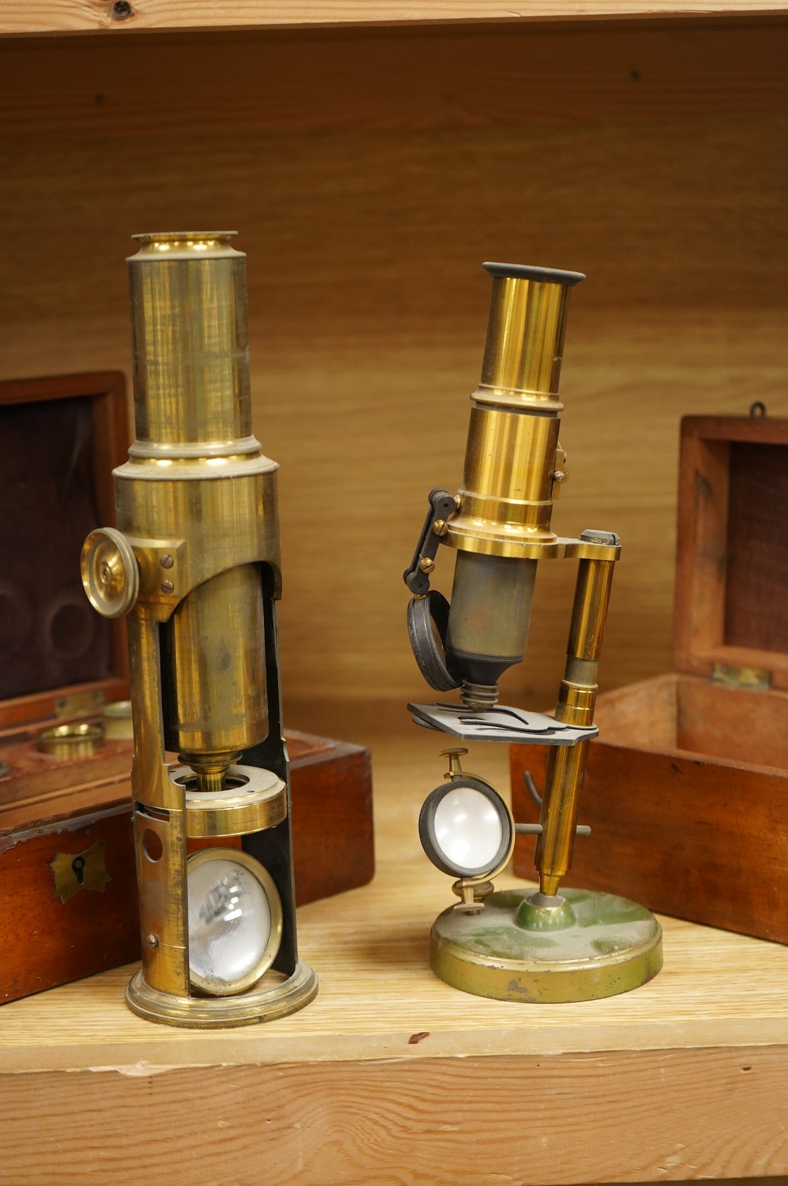 Two microscopes; an early 19th century Martin type brass compound monocular microscope, with five numbered objectives, specimen tube and hand magnifier, mahogany case 27cm wide, together with a late 19th/early 20th centu